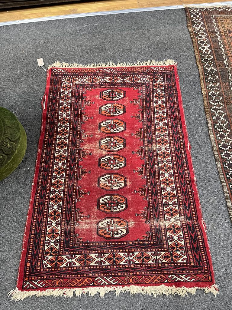 An antique Belouch red ground rug, 184 x 101cm together with a smaller Bokhara red ground rug